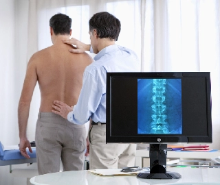 A doctor examing a person's back for back pain.